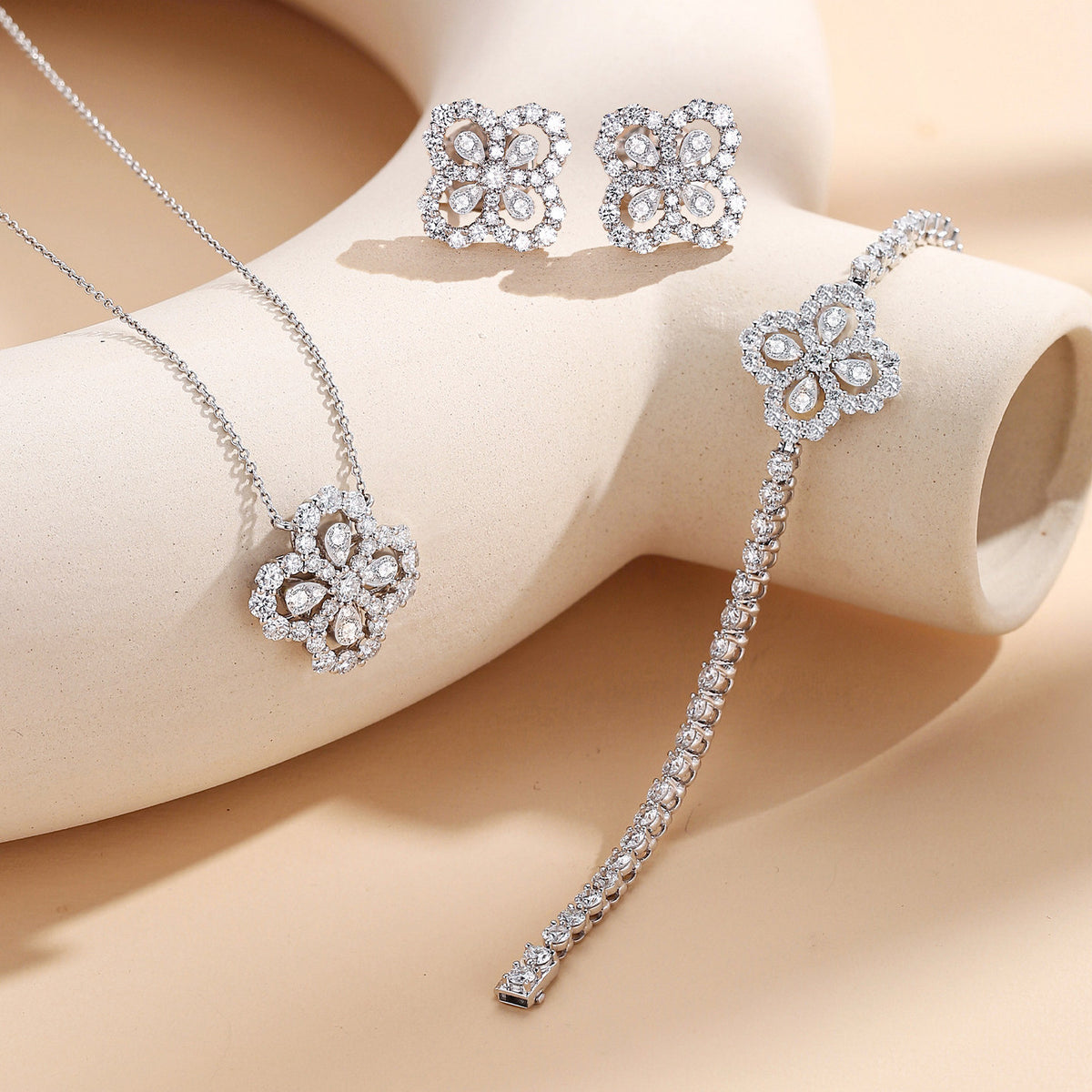 Clover halo lab-grown diamond necklace styled with matching earrings and bracelet