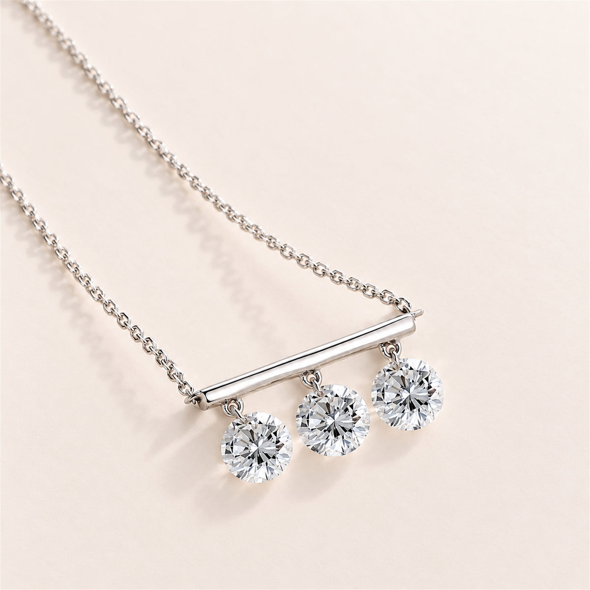 DANFÉE Three-stone lab-grown diamond bar necklace on a warm ivory background