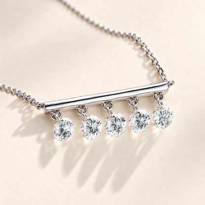 DANFÉE close-up of five floating round diamonds and polished white-metal bar on warm ivory