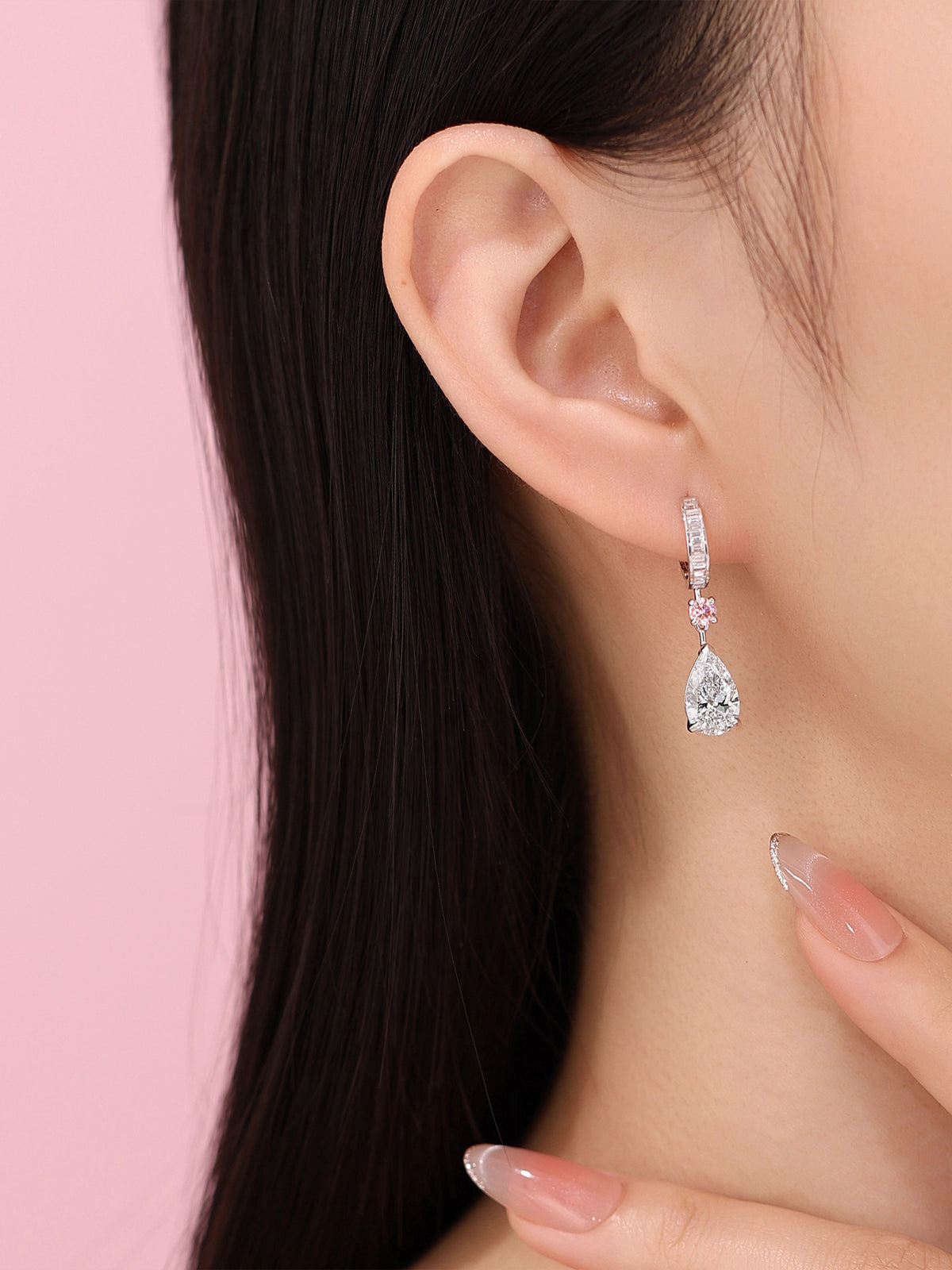 Model wearing the white pear diamond earring with pink round accent