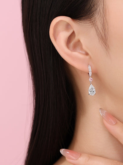 Model wearing the white pear diamond earring with pink round accent
