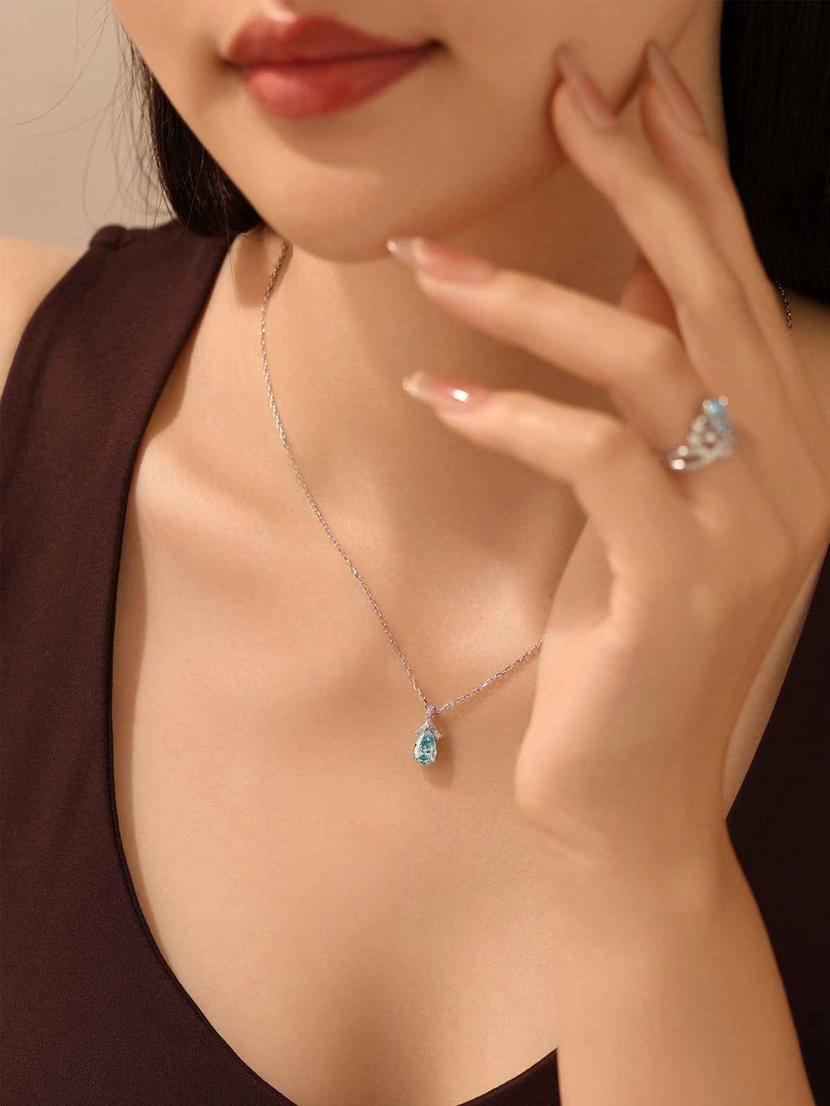Model wearing the DANFÉE Ribbon Bow Pear blue diamond necklace
