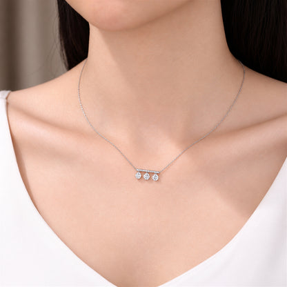 DANFÉE Three-stone lab-grown diamond bar necklace worn with a white neckline