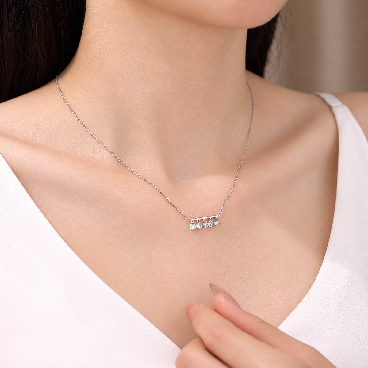 DANFÉE Five-diamond bar necklace worn with a pale V-neck