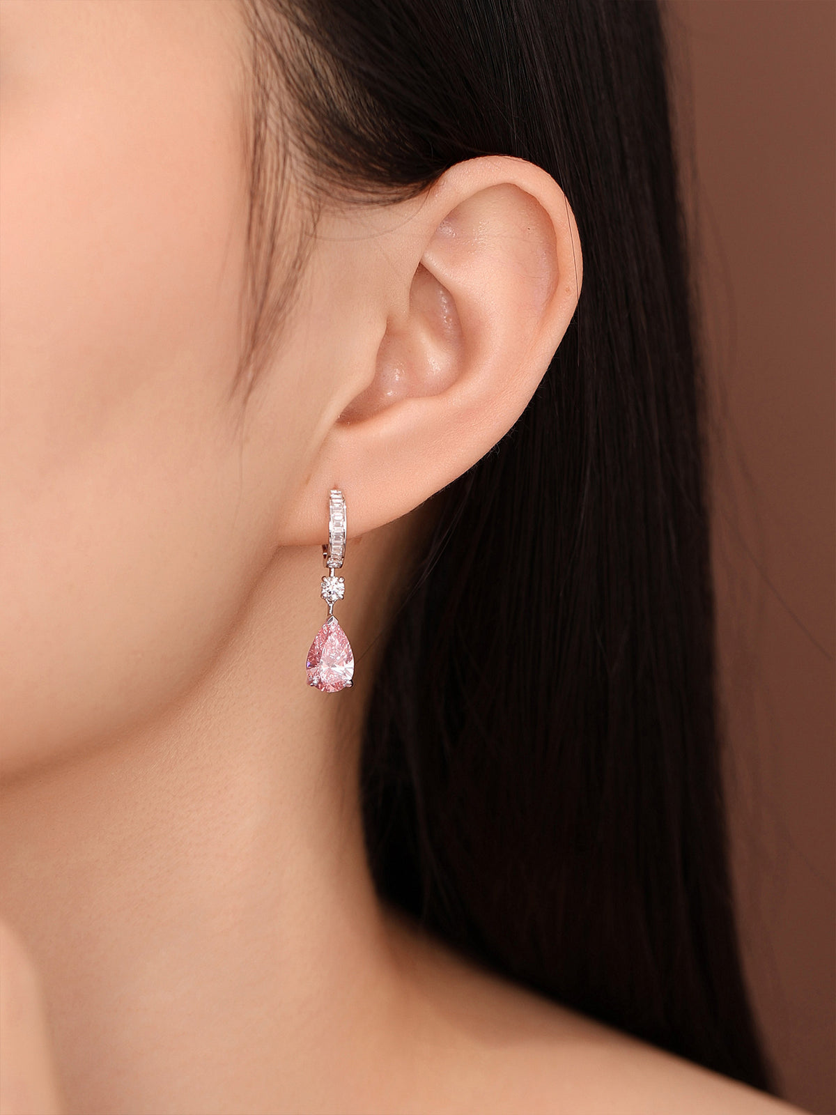 Close-up of the pink pear diamond drop earring on the ear