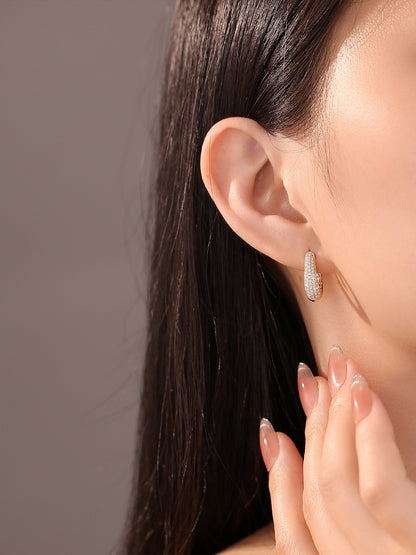 18K gold dome pavé huggie earring worn on the ear
