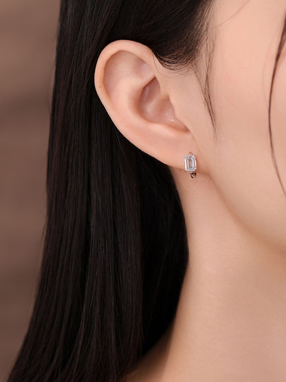 Emerald-cut diamond huggie earring worn on the ear