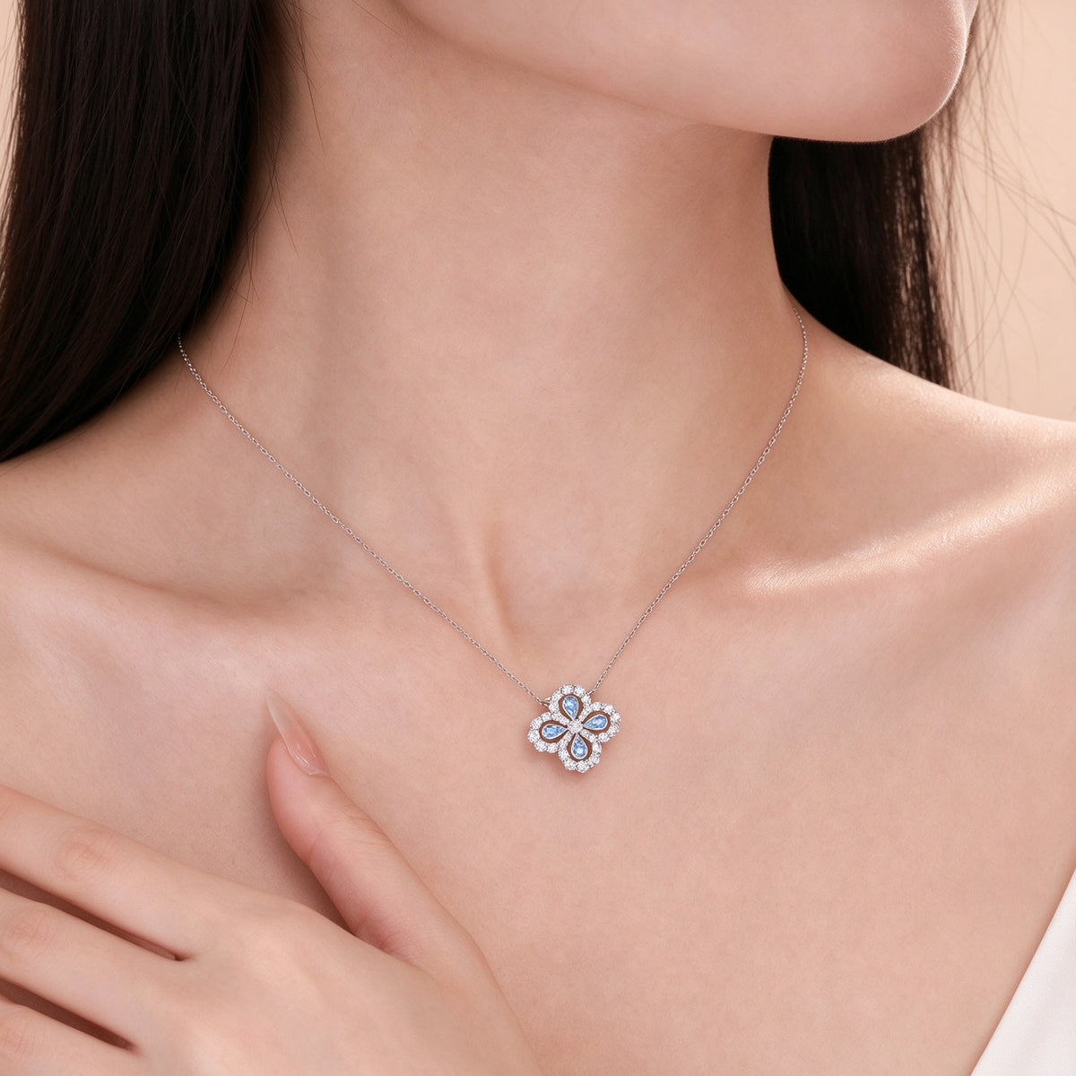 Model wearing the Clover Loop diamond and blue spinel necklace