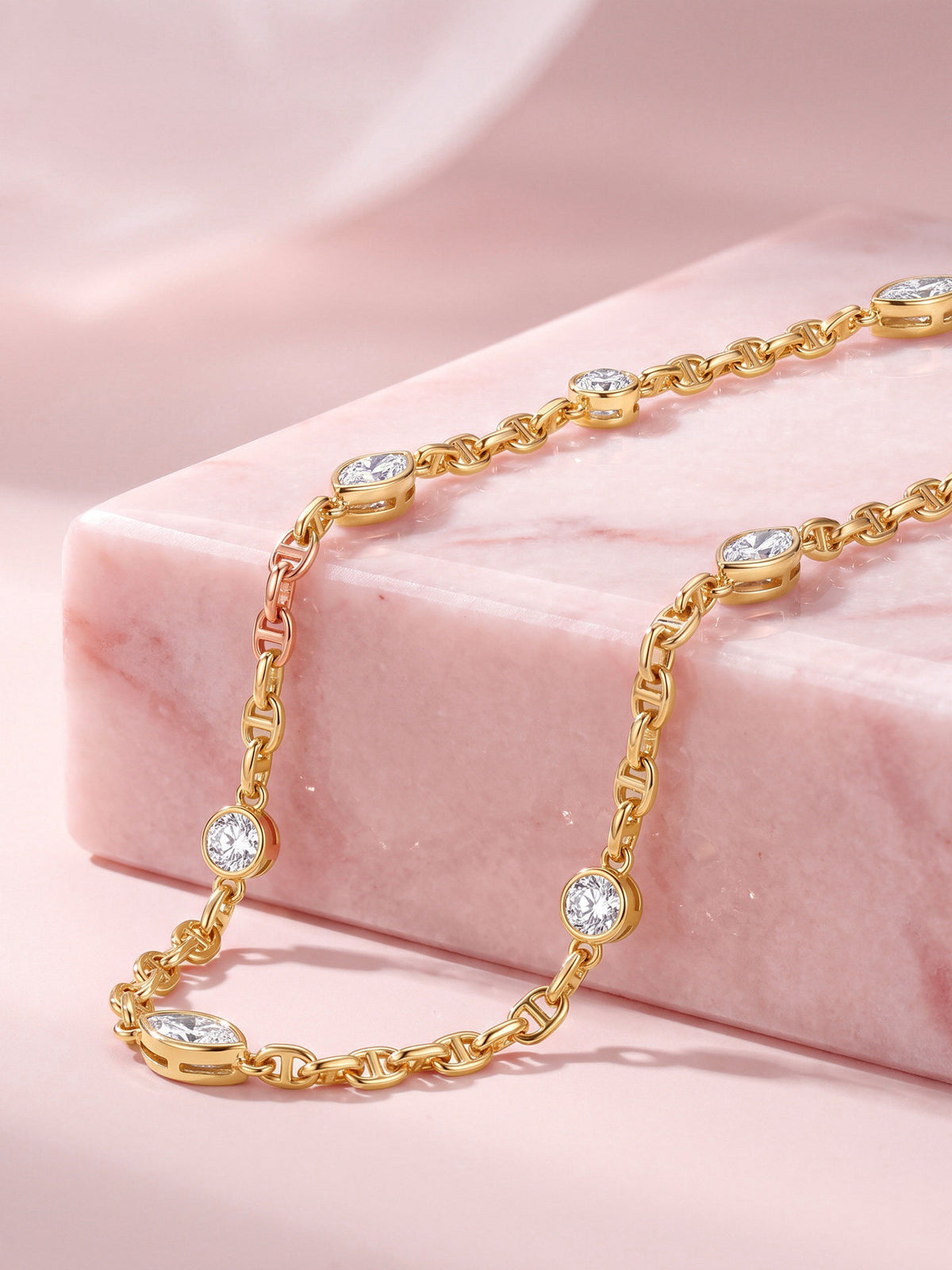 Lab-grown diamond station necklace in 18K yellow gold on pink marble