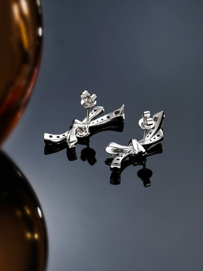 PT950 platinum bow earrings back with hallmark on a mirrored surface