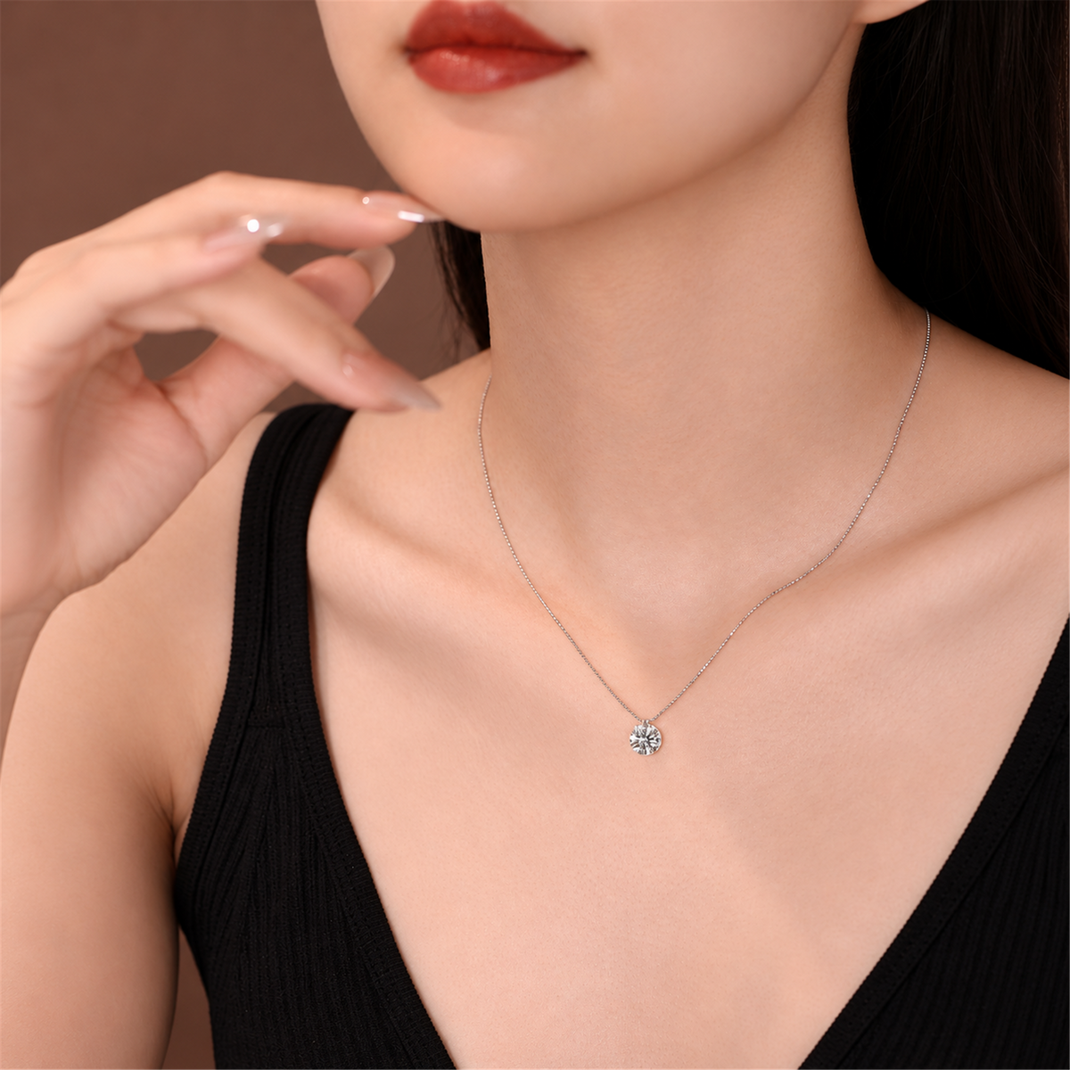 Round solitaire diamond necklace worn with a black top; edited supplier styling photo