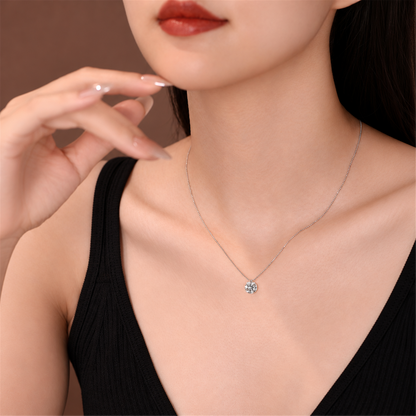 Round solitaire diamond necklace worn with a black top; edited supplier styling photo