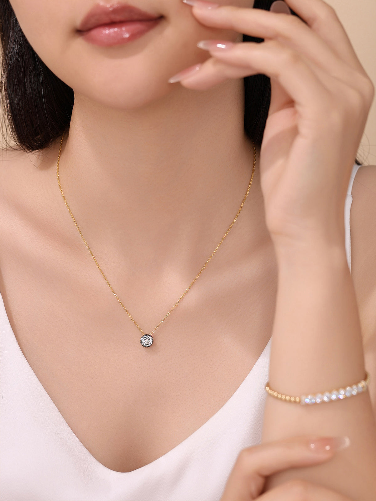 DANFÉE 1 carat lab-grown diamond necklace in 18K yellow gold worn with a white top, hand beside face