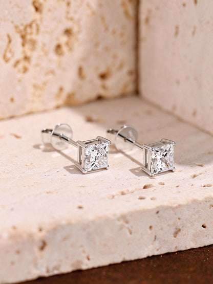Princess-cut diamond solitaire studs in 18K white gold on travertine stone