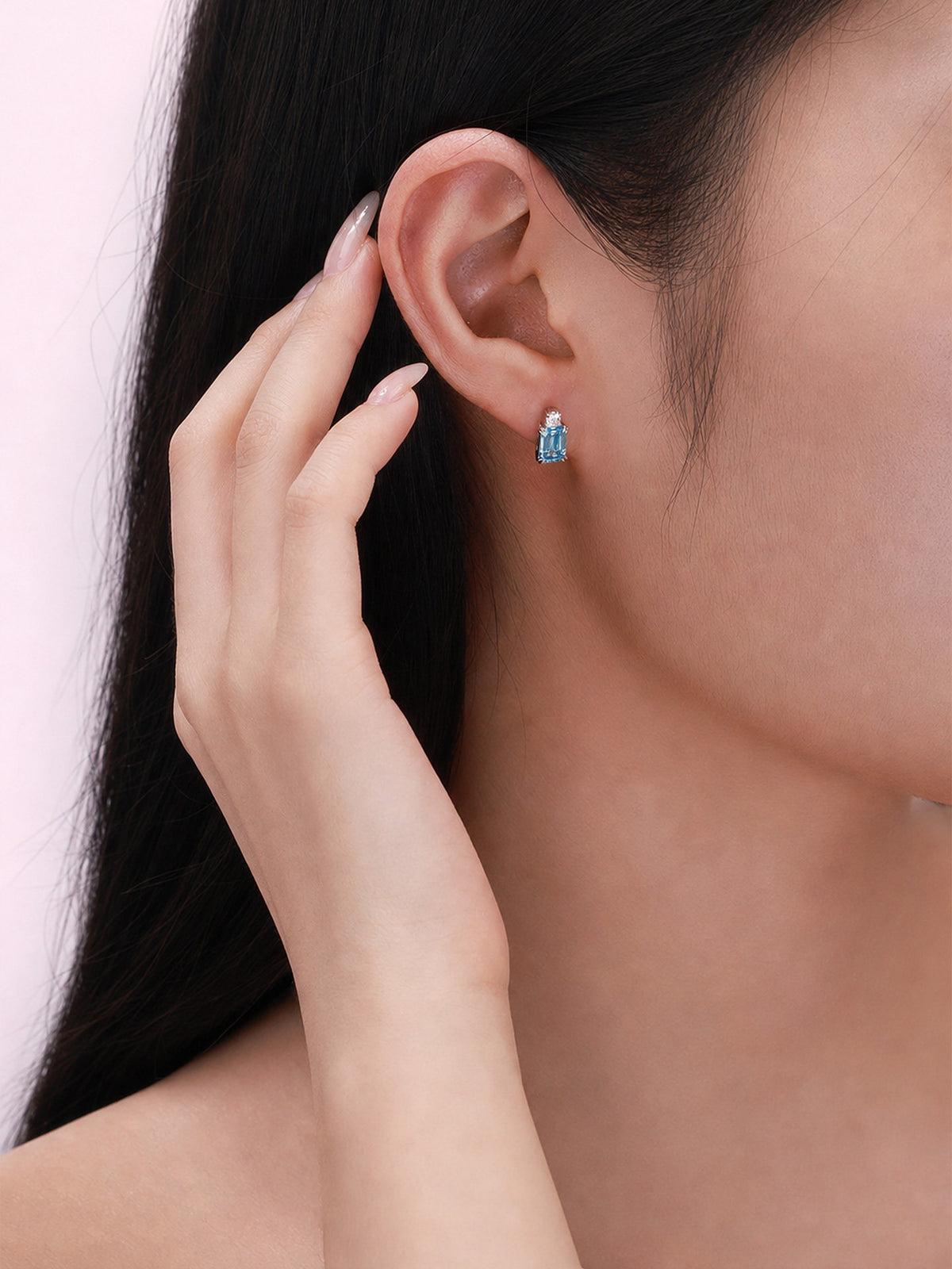 Model wearing blue emerald-cut lab-grown diamond stud earring