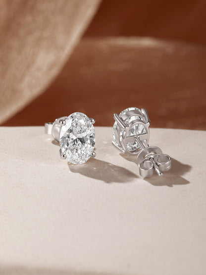 Céleste oval diamond stud earrings showing four-claw setting and 18K gold butterfly back