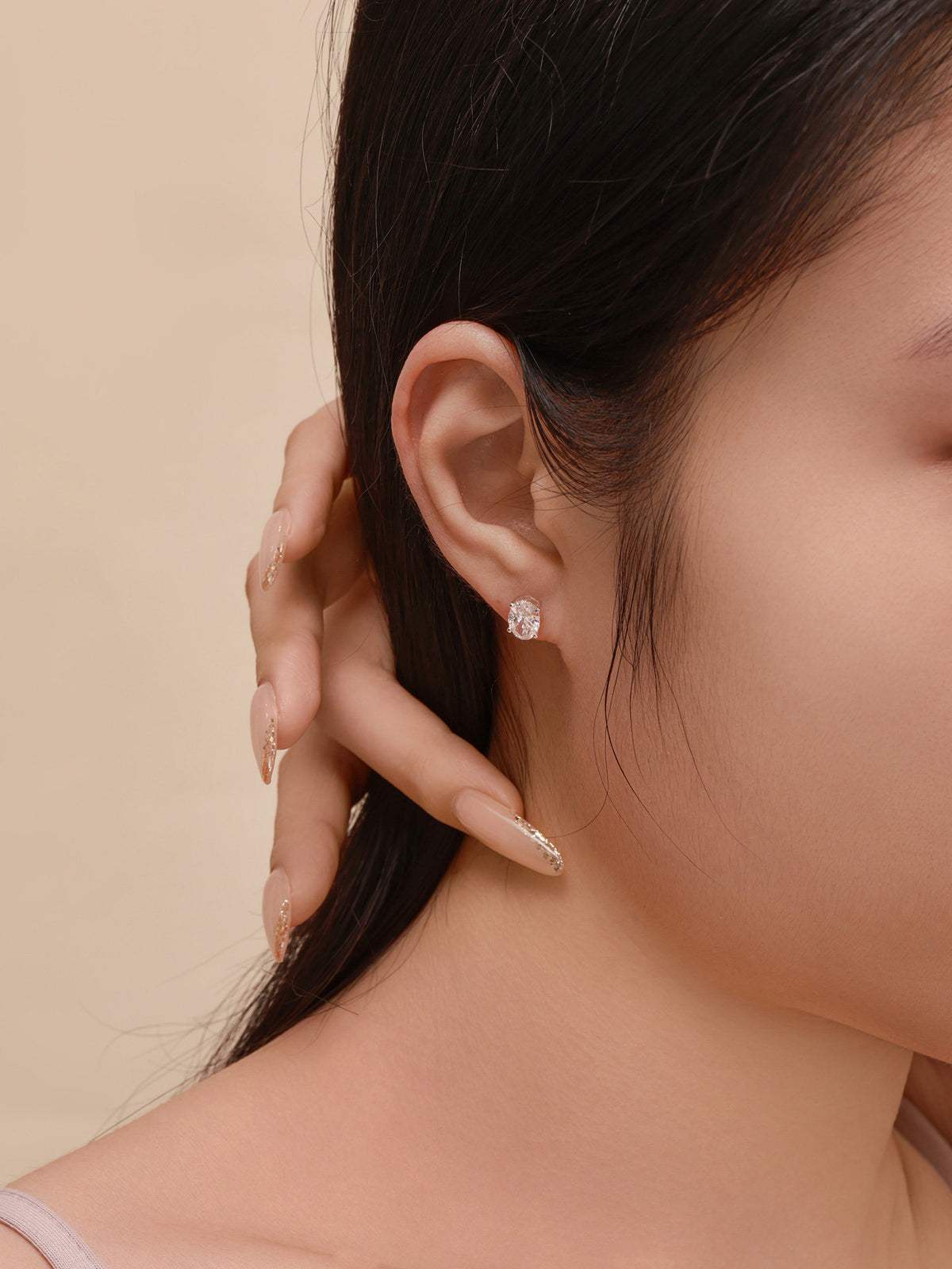 Model wearing Céleste oval lab-grown diamond stud earring in 18K white gold
