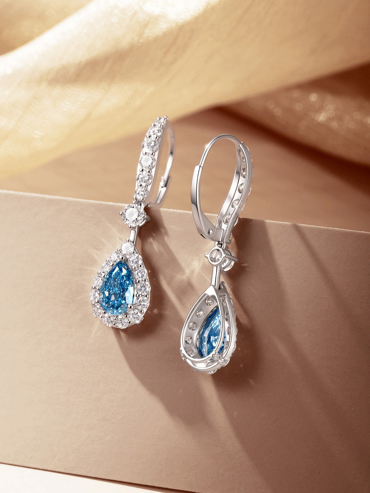 Front and back view of blue lab-grown diamond halo drop earrings in 18K white gold