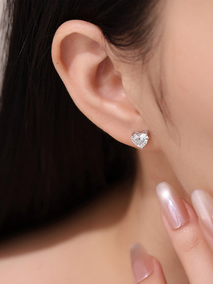 Close-up of three-prong heart diamond stud earring on the earlobe