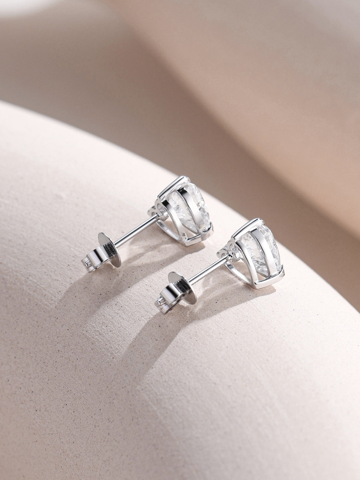 Heart diamond stud earrings in 18K white gold, profile view with push backs