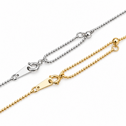 White and yellow gold bead chain clasps and tag details on white; digitally retouched supplier image