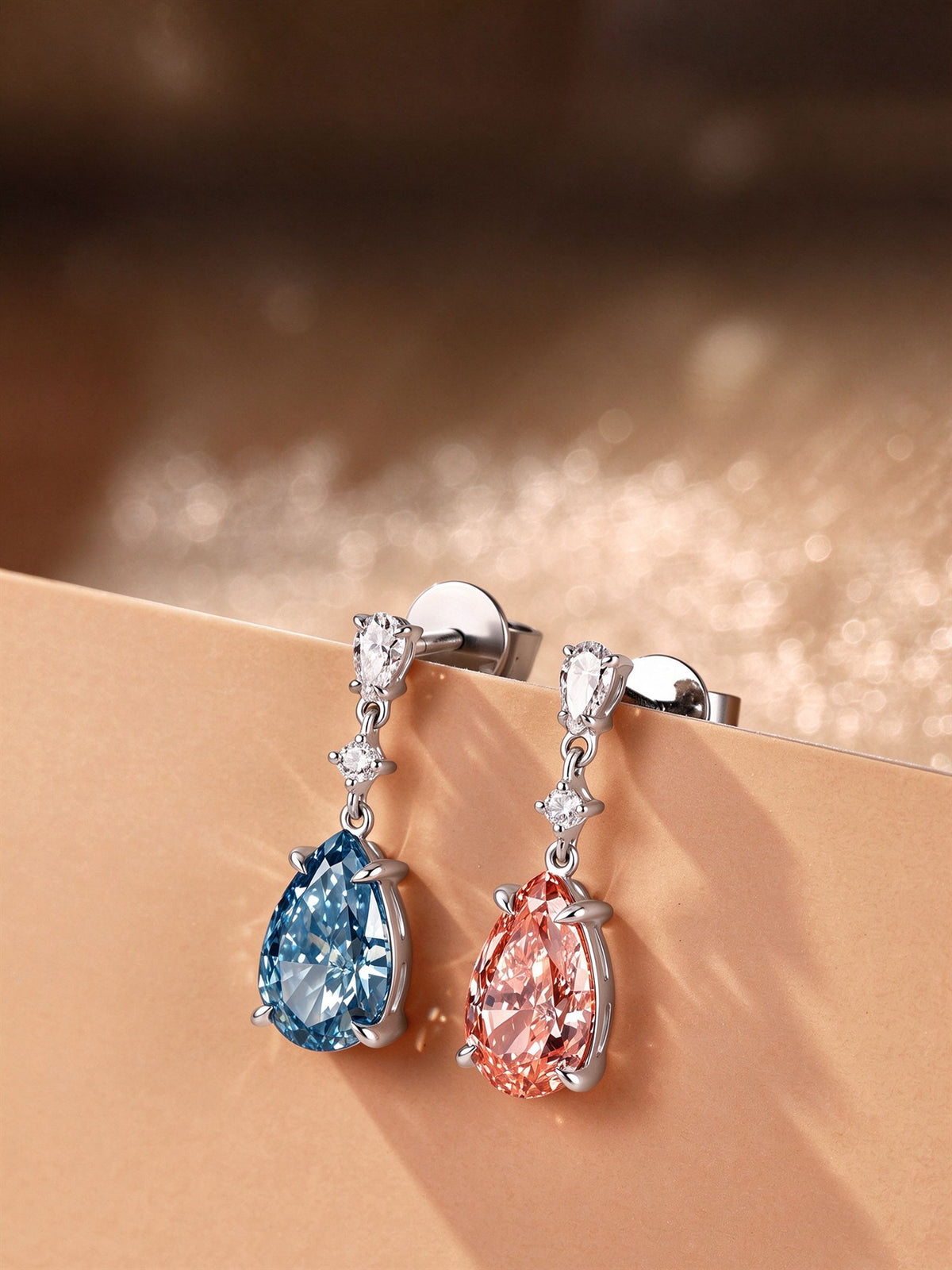 DANFÉE Duet blue and pink lab-grown diamond drop earrings displayed on a warm-toned ledge