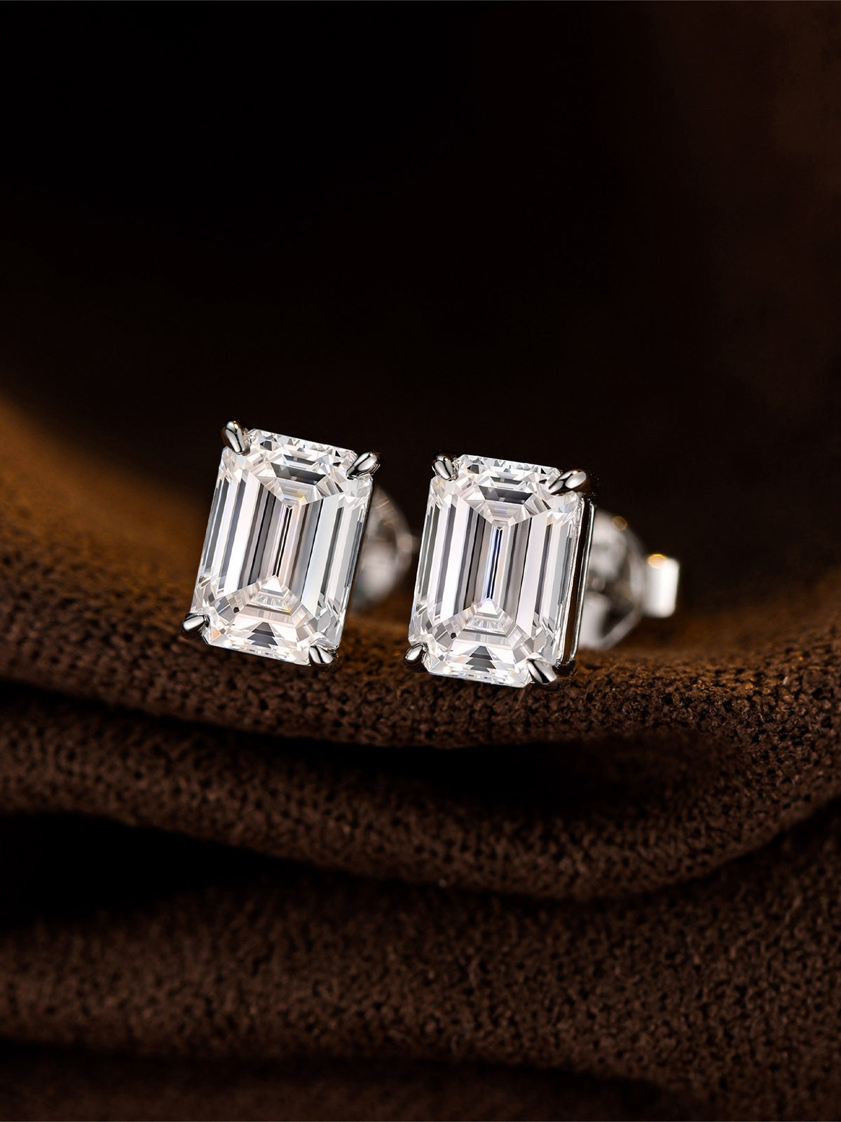 Emerald-cut lab-grown diamond stud earrings in 18K white gold on brown suede