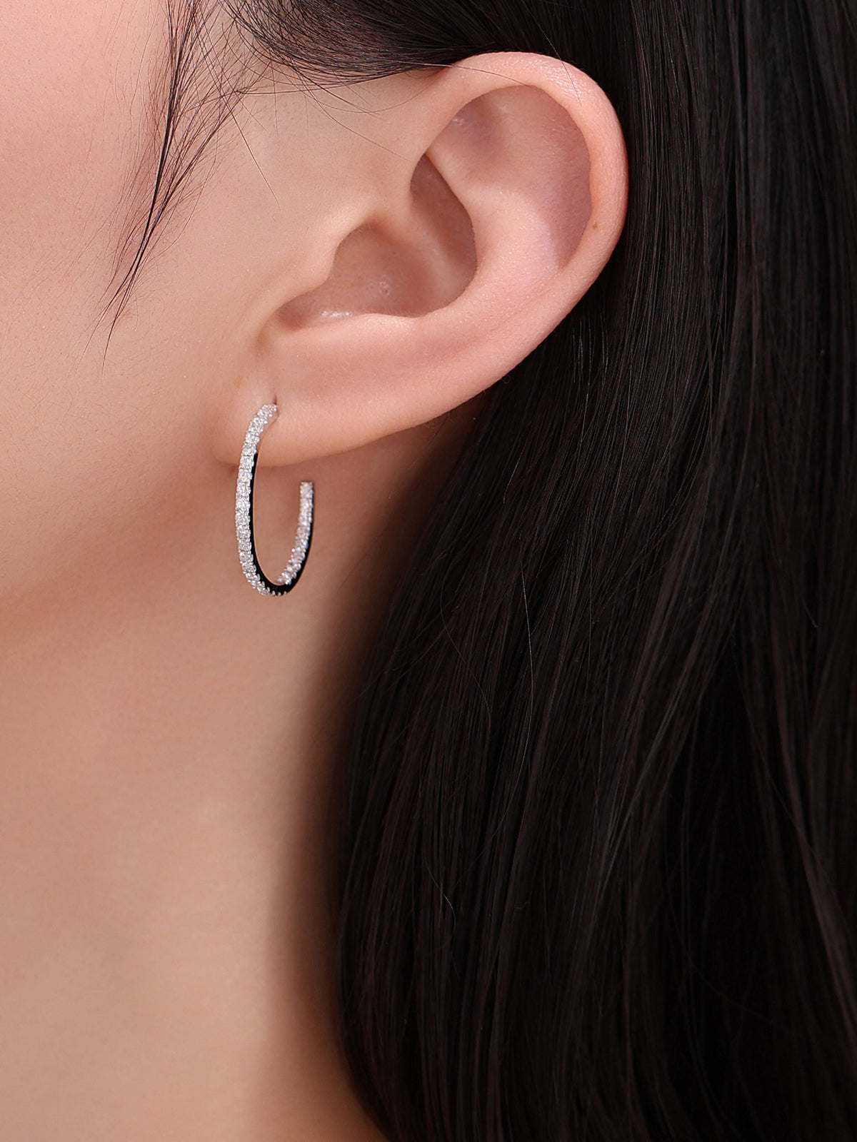 Close-up of the open diamond hoop earring on the ear