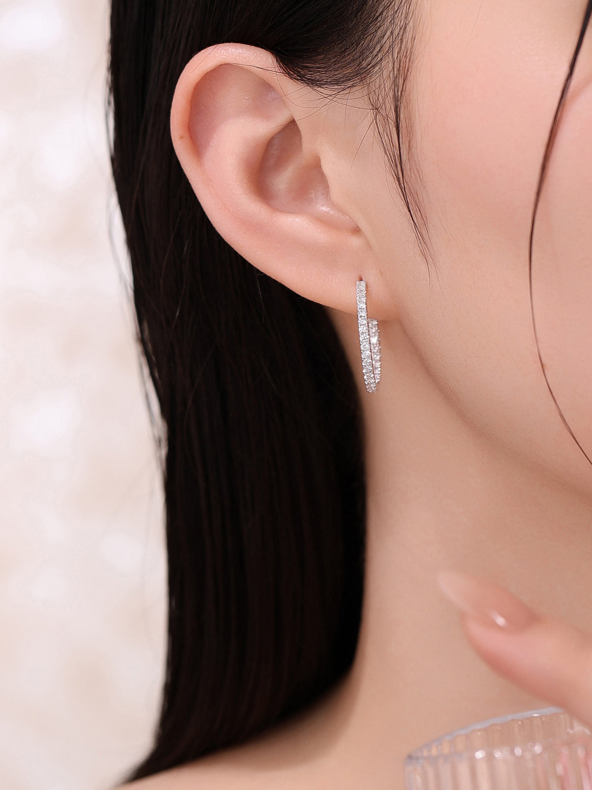 Diamond-set inner edge of the 18K gold hoop earring, worn on the ear