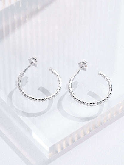 Open hoop earrings set with round lab-grown diamonds inside and out, lying flat