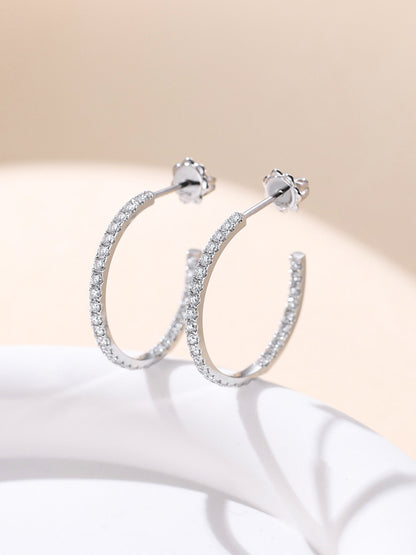 18K gold inside-out diamond hoop earrings standing on a white pedestal