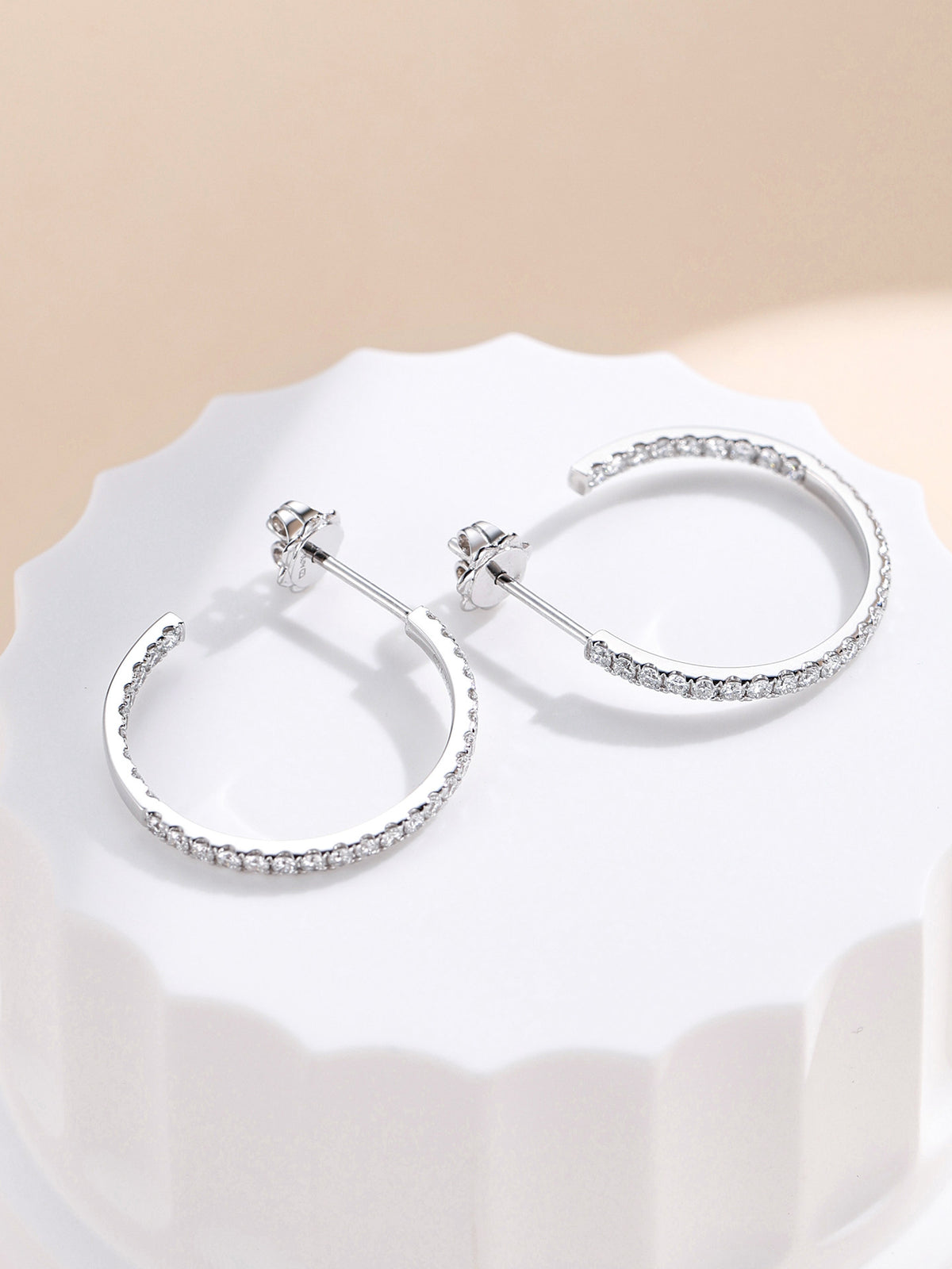 Side view of the diamond hoop earrings showing the post and 18K hallmarked push back