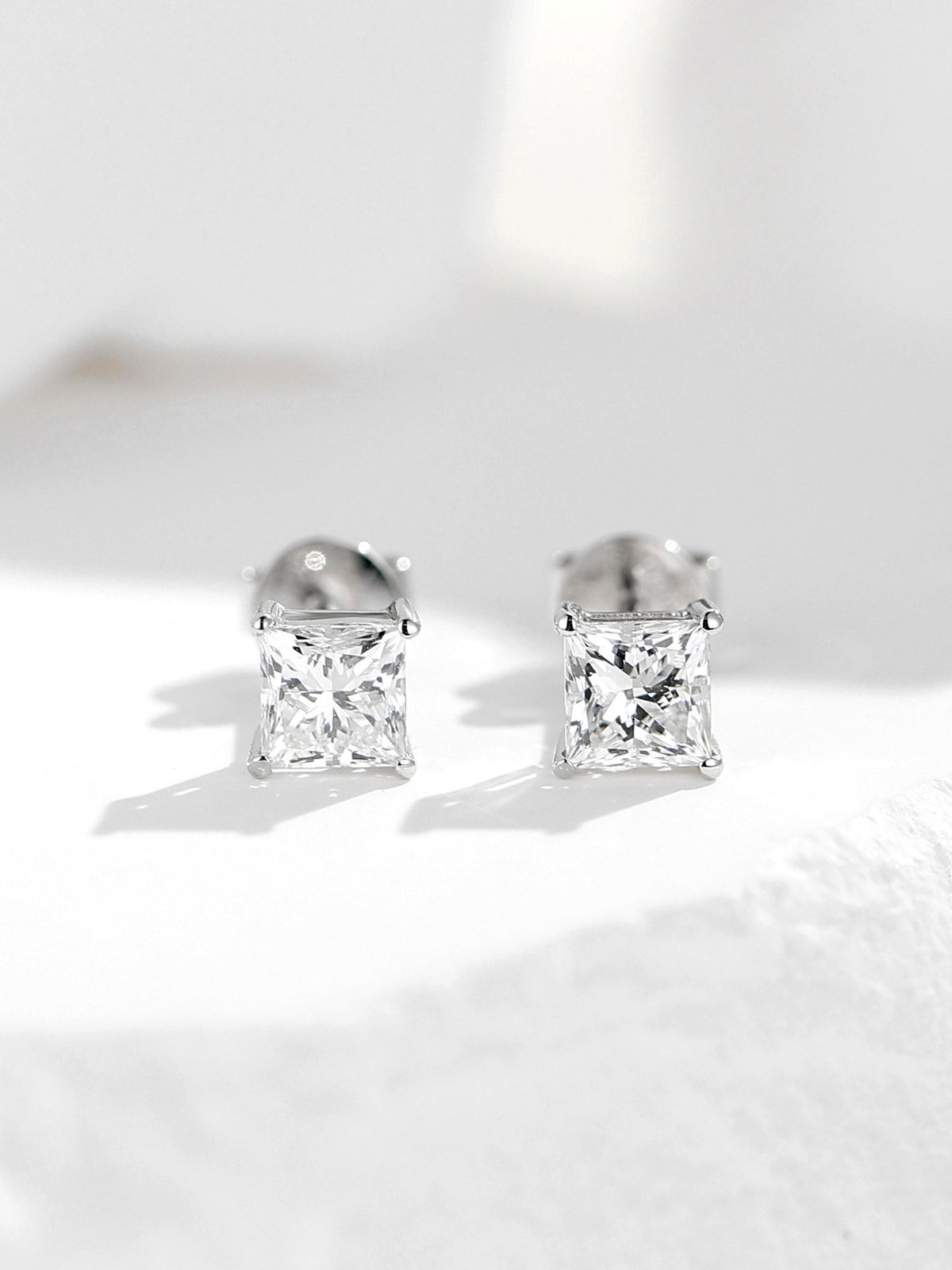 Pair of lab-grown diamond solitaire stud earrings in 18K white gold with four-claw settings