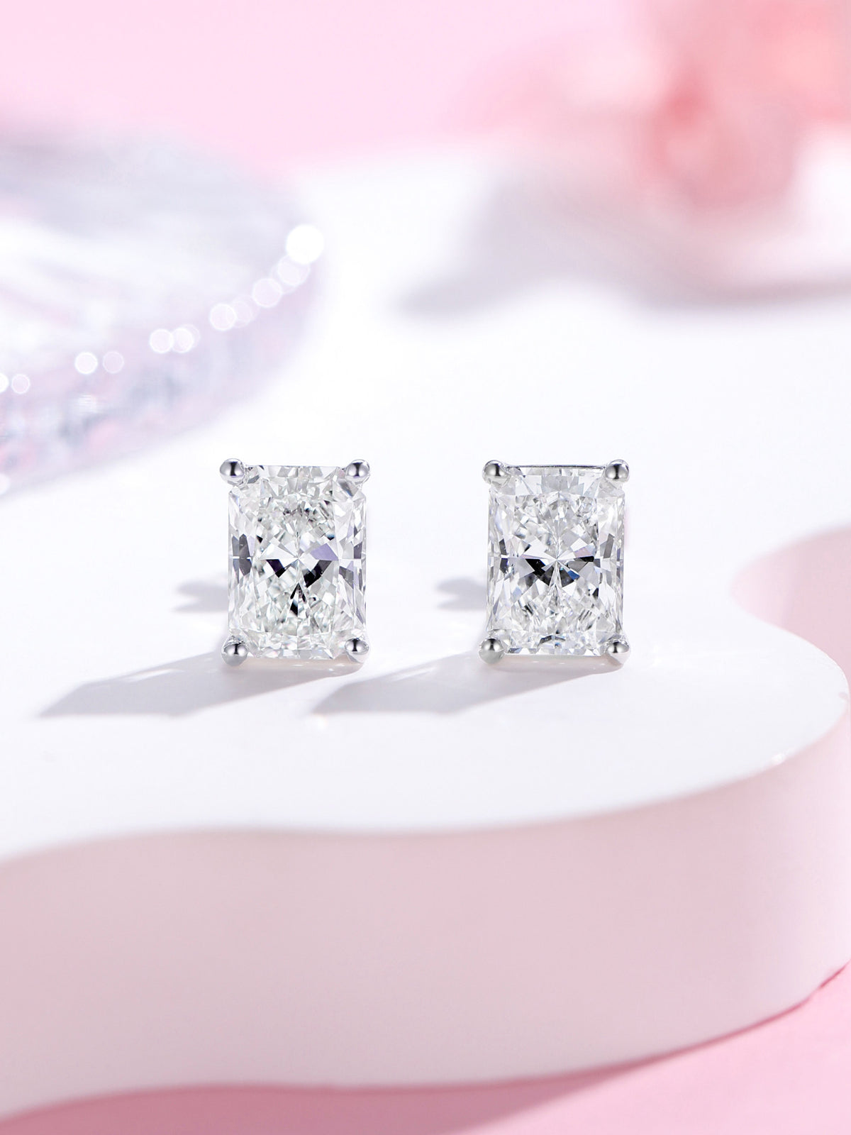 Radiant-cut lab-grown diamond stud earrings in 18K white gold on a soft pink backdrop