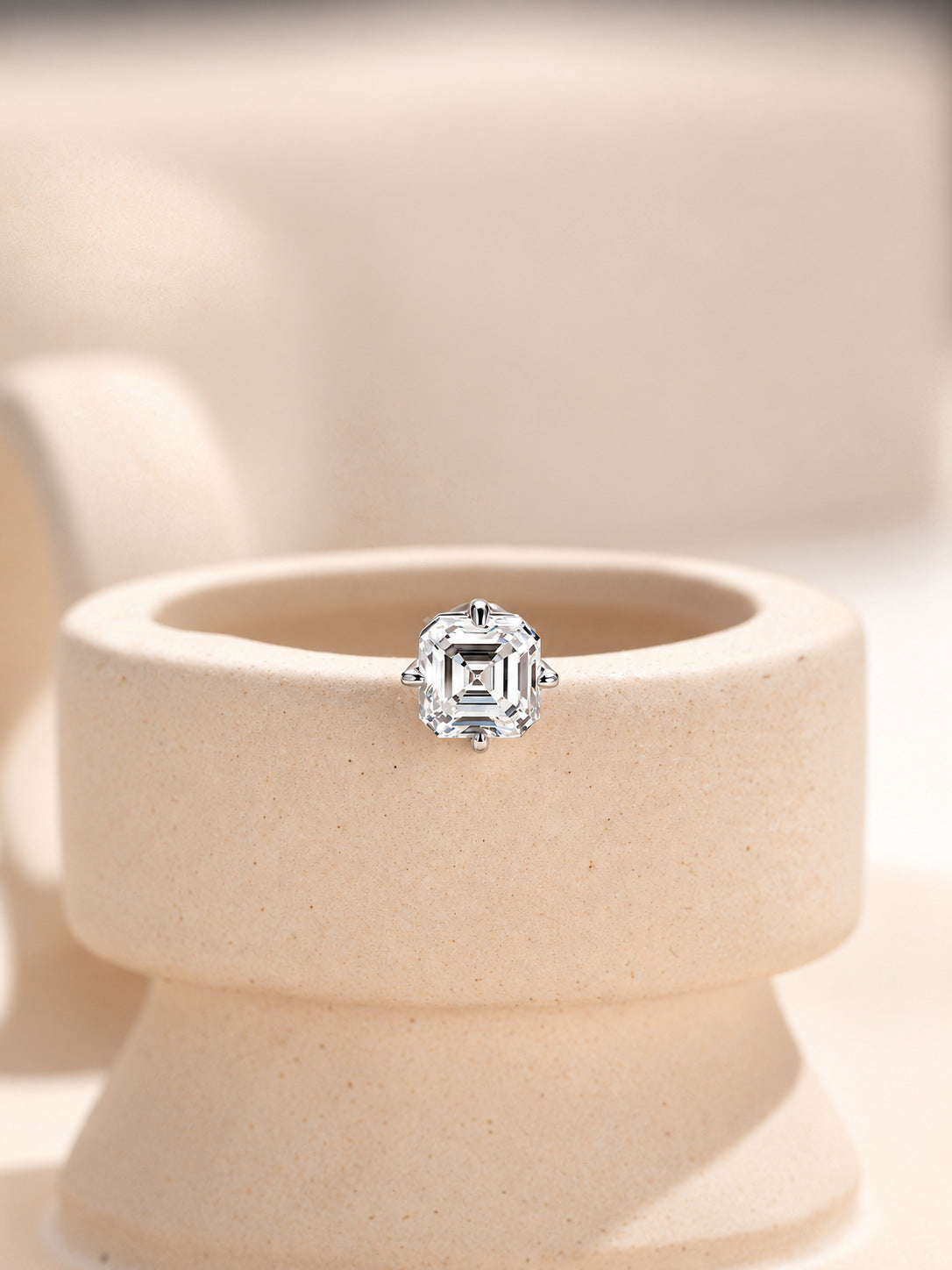 Single Asscher-cut lab-grown diamond stud earring displayed on a stone pedestal