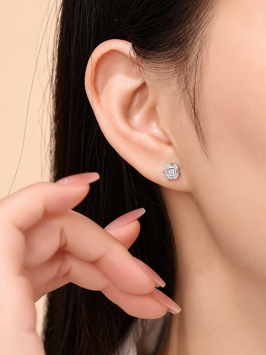 Model wearing the 1 carat Asscher-cut lab-grown diamond stud earring in 18K white gold