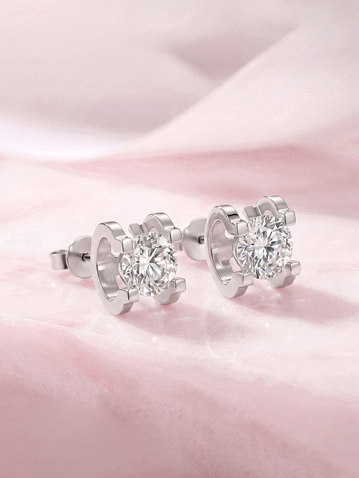 Four-claw round lab-grown diamond stud earrings in 18K white gold on pink silk