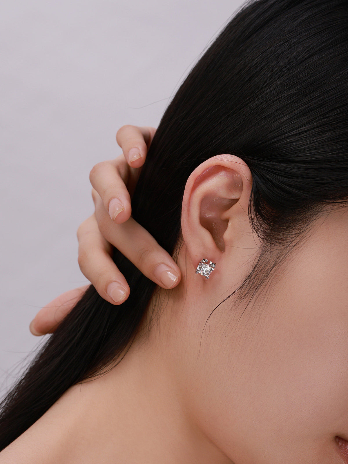 18K white gold diamond solitaire stud worn with hair swept back