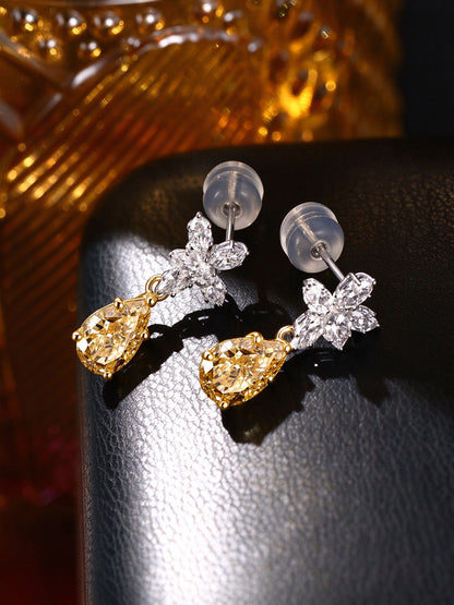 Pair of Floraison pear-cut yellow diamond earrings on black leather