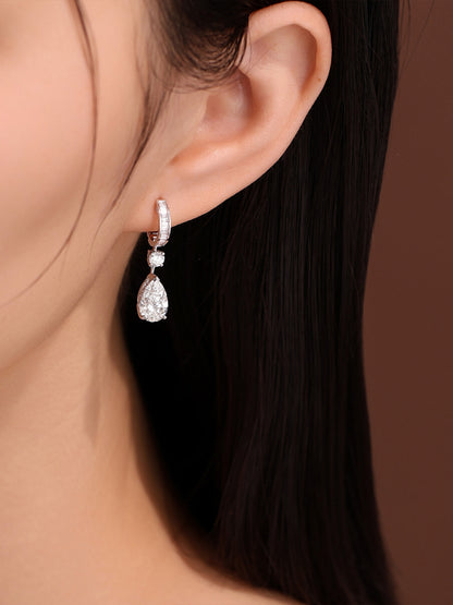 Close-up of the pear-cut diamond drop earring with baguette huggie worn on the ear