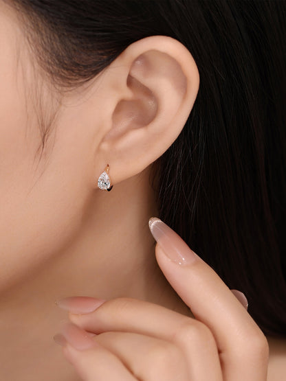 Close-up of pear-cut lab-grown diamond huggie earring on ear