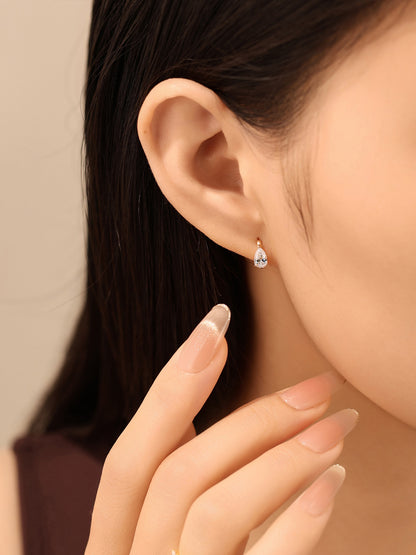Lab-grown pear diamond huggie earring on model, everyday wear