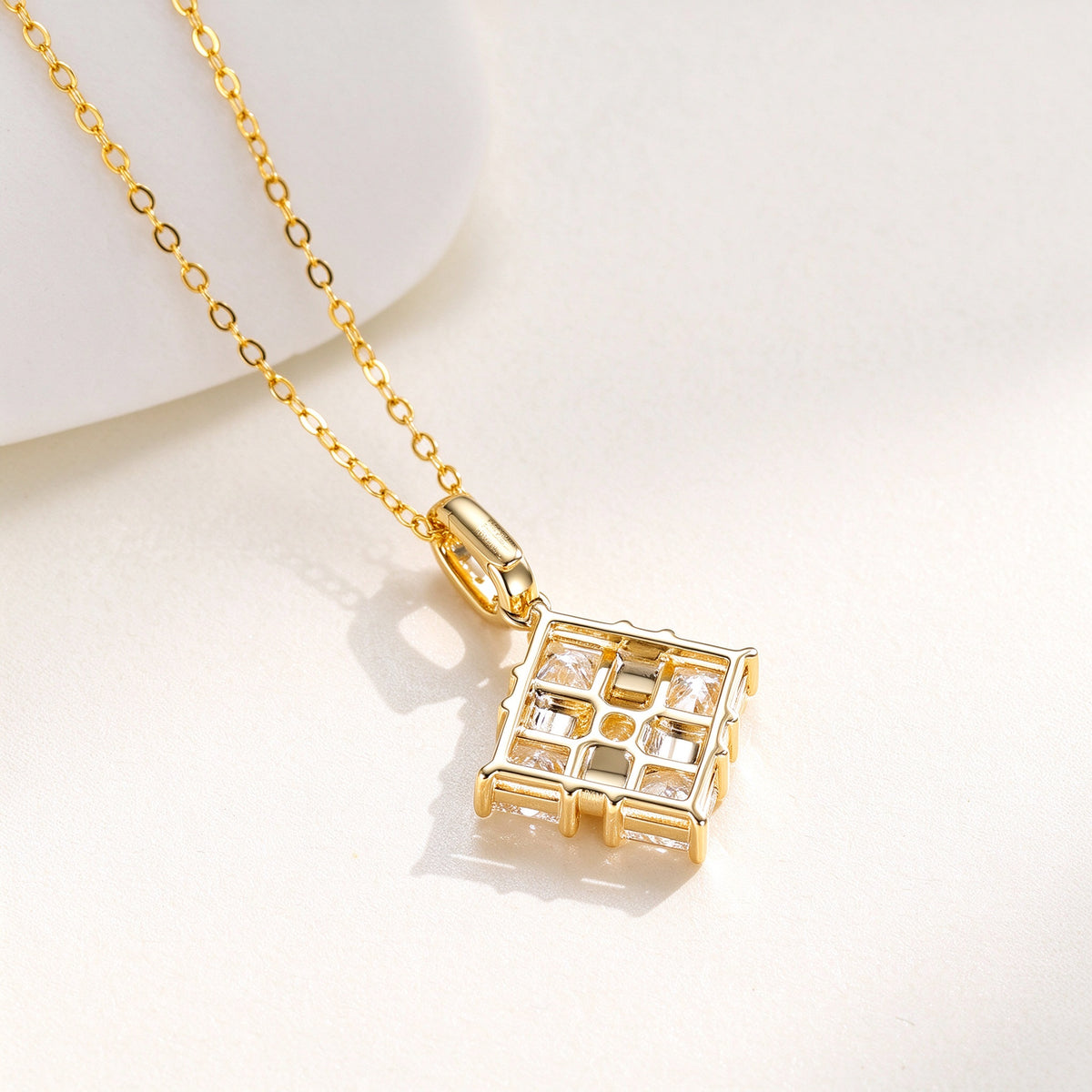 Ribbon Box diamond pendant in 18K yellow gold, back view on ivory