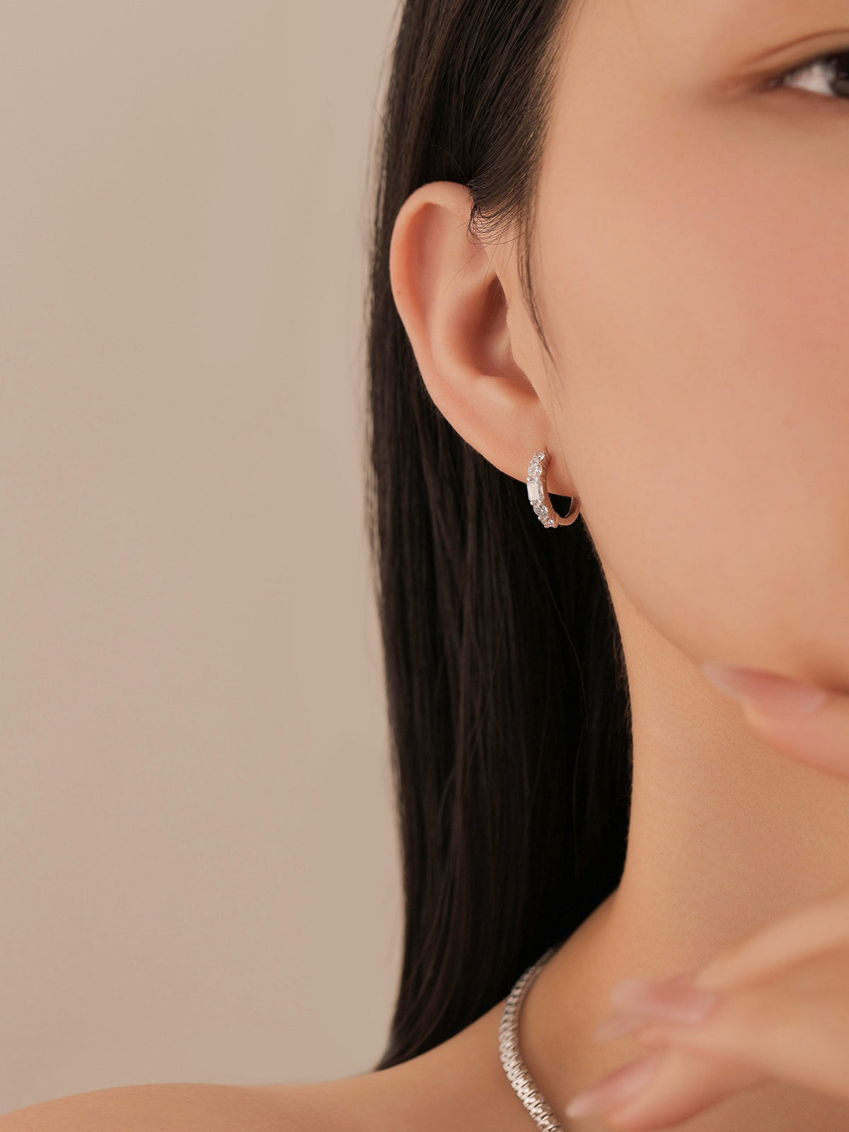 Model wearing the emerald-cut lab-grown diamond huggie earring in PT950 platinum