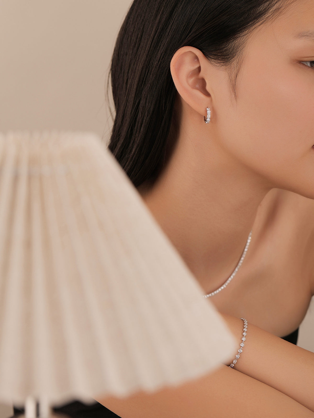 Lab-grown diamond huggie earrings worn with a tennis necklace and bracelet