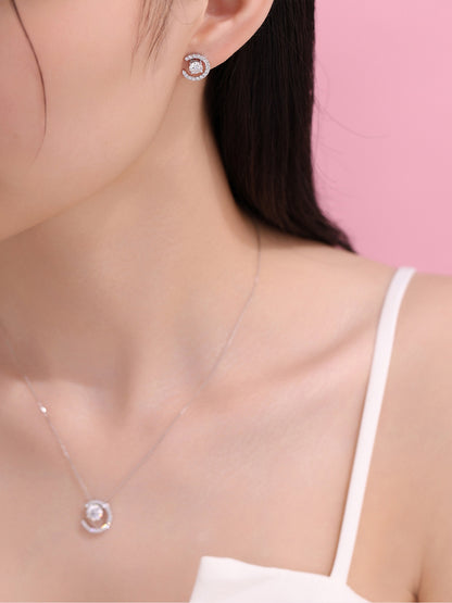 Model wearing the Lune crescent diamond earring and pendant against pink