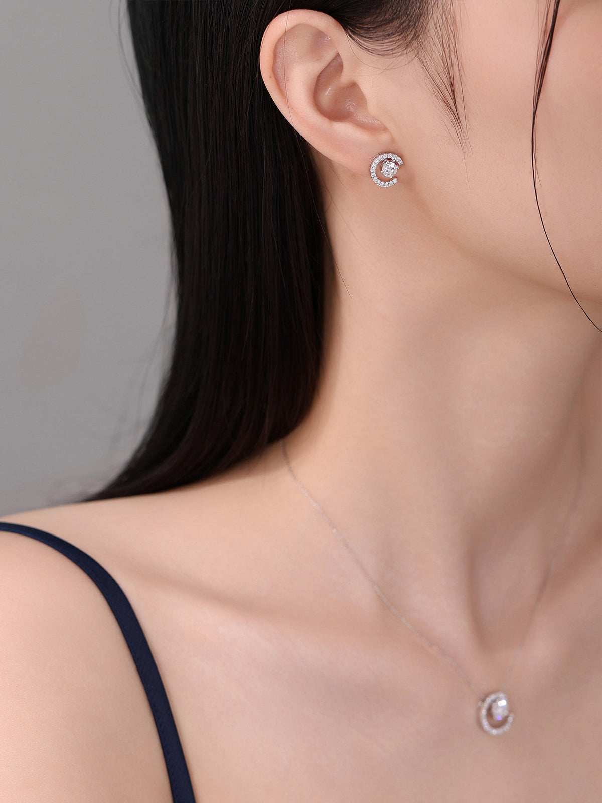 Model wearing the Lune crescent diamond earring with a matching pendant
