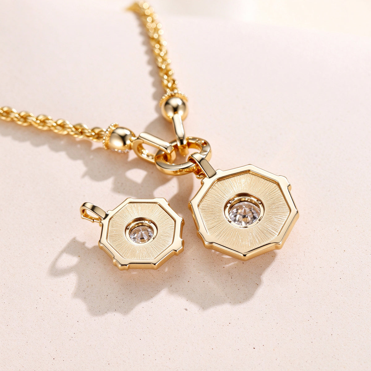 DANFÉE octagon halo pendants, open-back setting and rope chain clasp detail on cream