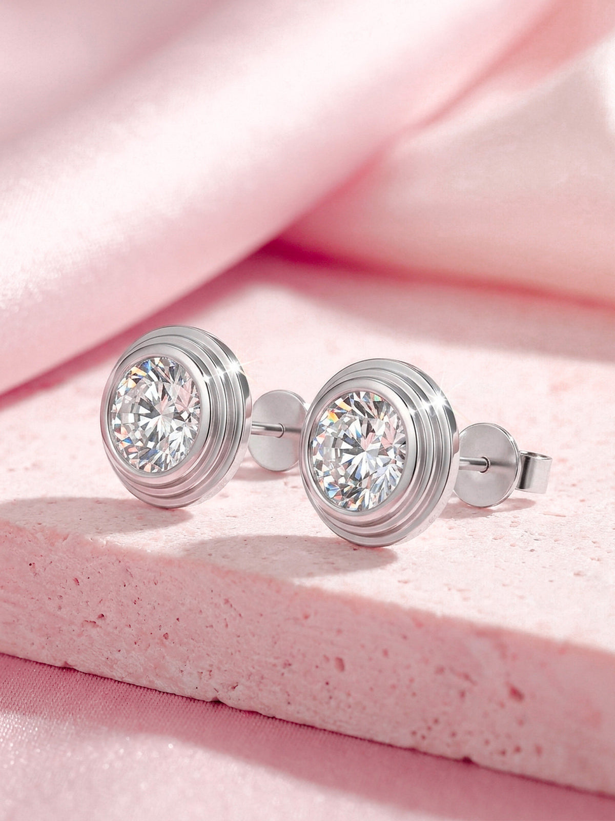 Round lab-grown diamond bezel studs in 18K white gold on pink stone