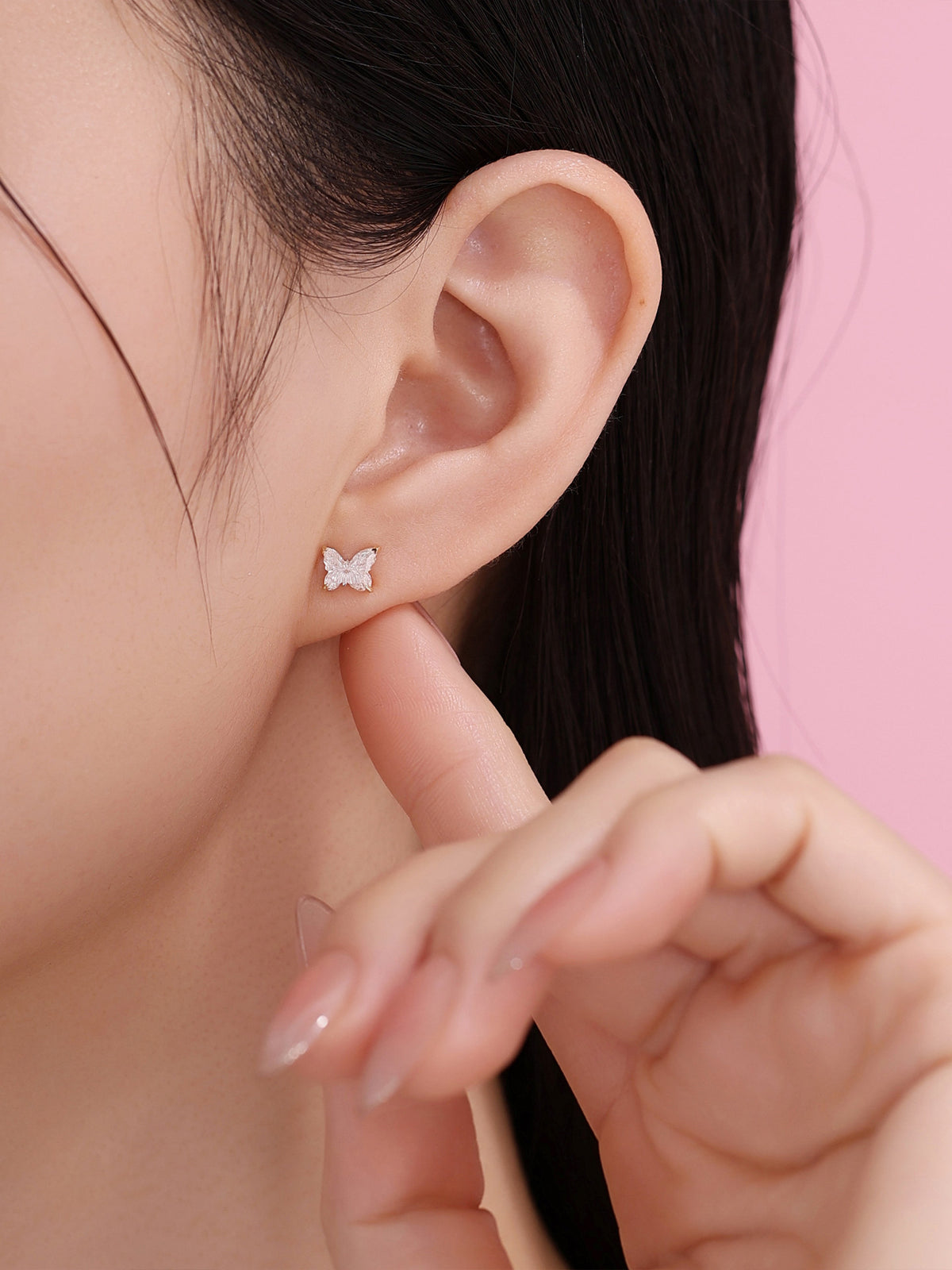 Model wearing an 18K gold butterfly diamond stud earring, side view